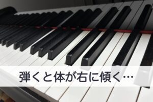 「弾くと体が右に傾く…」の文字を入れた、斜めから見たグランドピアノの鍵盤